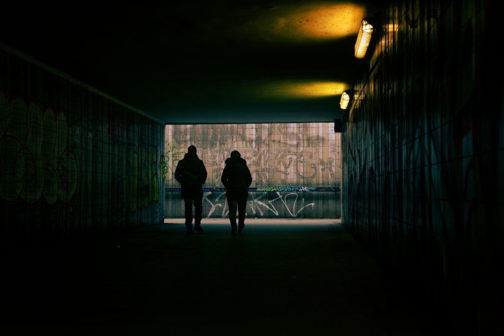 a couple of people that are walking in a tunnel