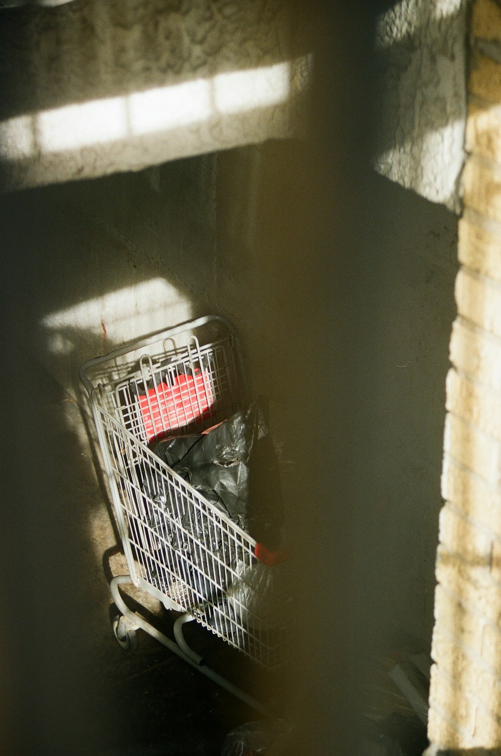 a shopping cart sitting in a corner of a building