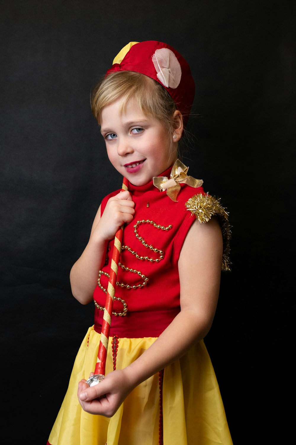 a little girl dressed in a red and yellow costume