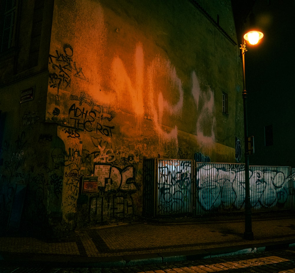 a street light next to a building with graffiti on it