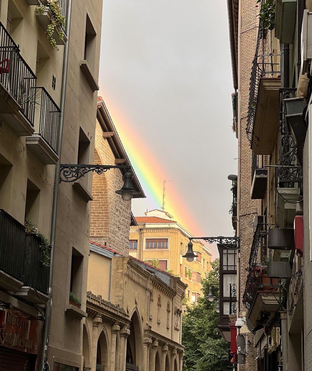 a rainbow in the sky over a city street