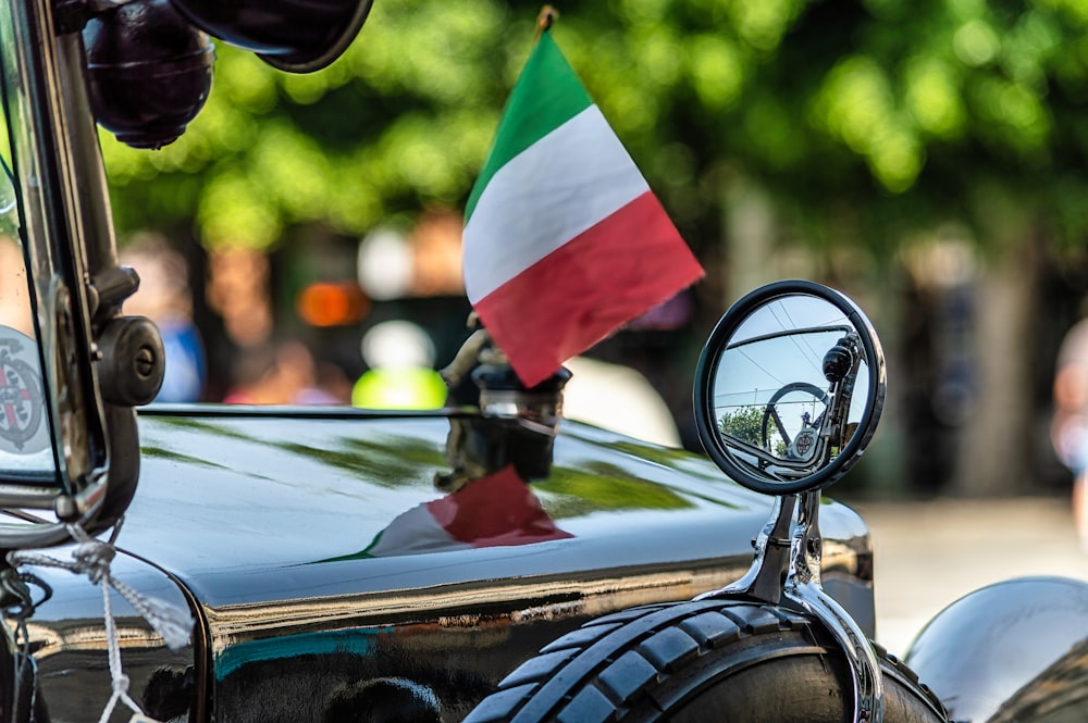 uno specchietto retrovisore laterale su un'auto con una bandiera su di esso