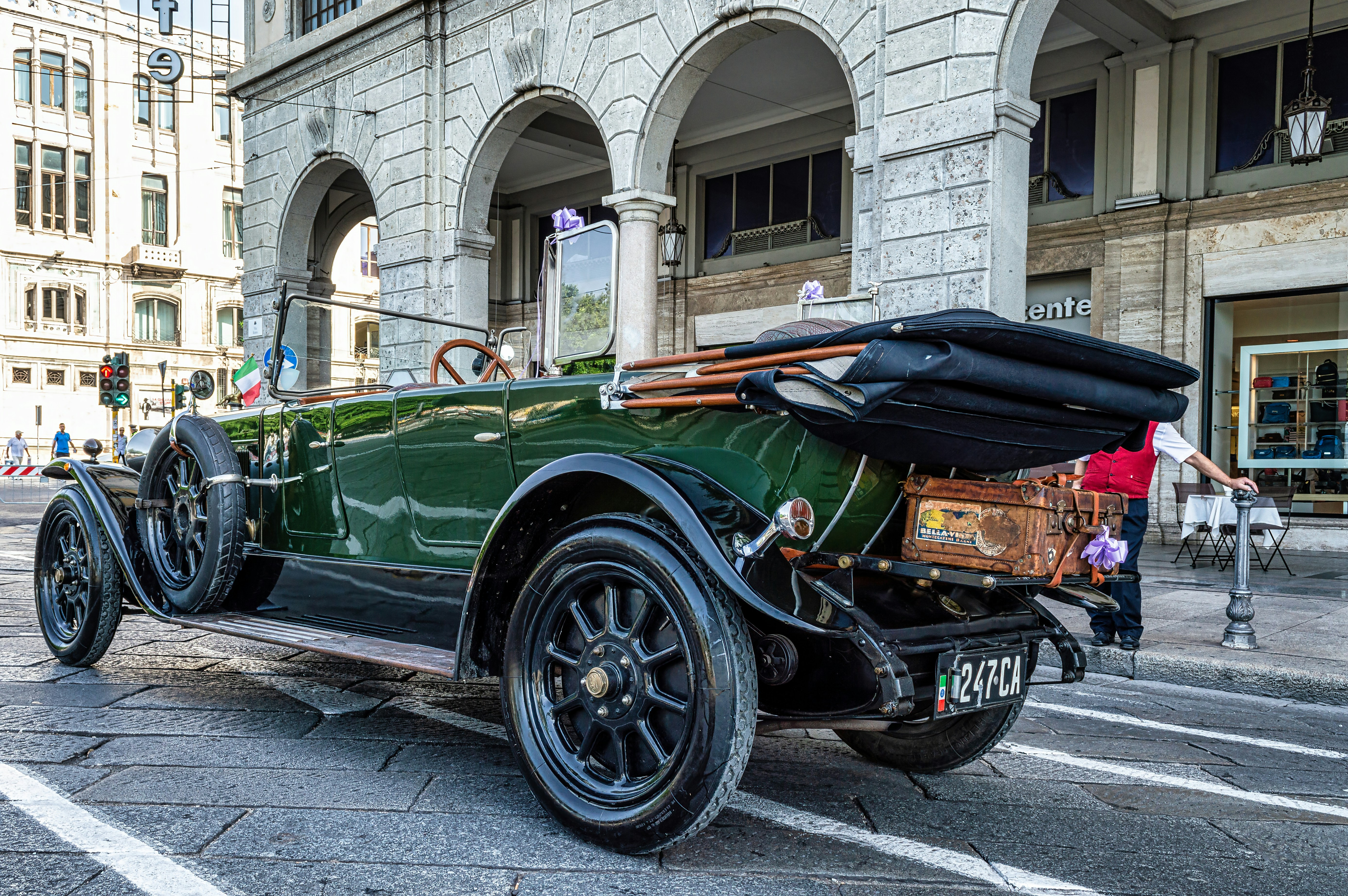 una vecchia auto verde parcheggiata davanti a un edificio