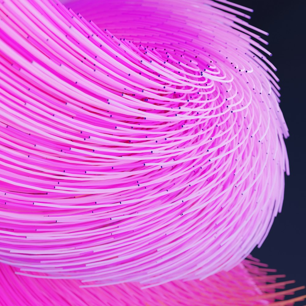 a close up of a pink object with a black background