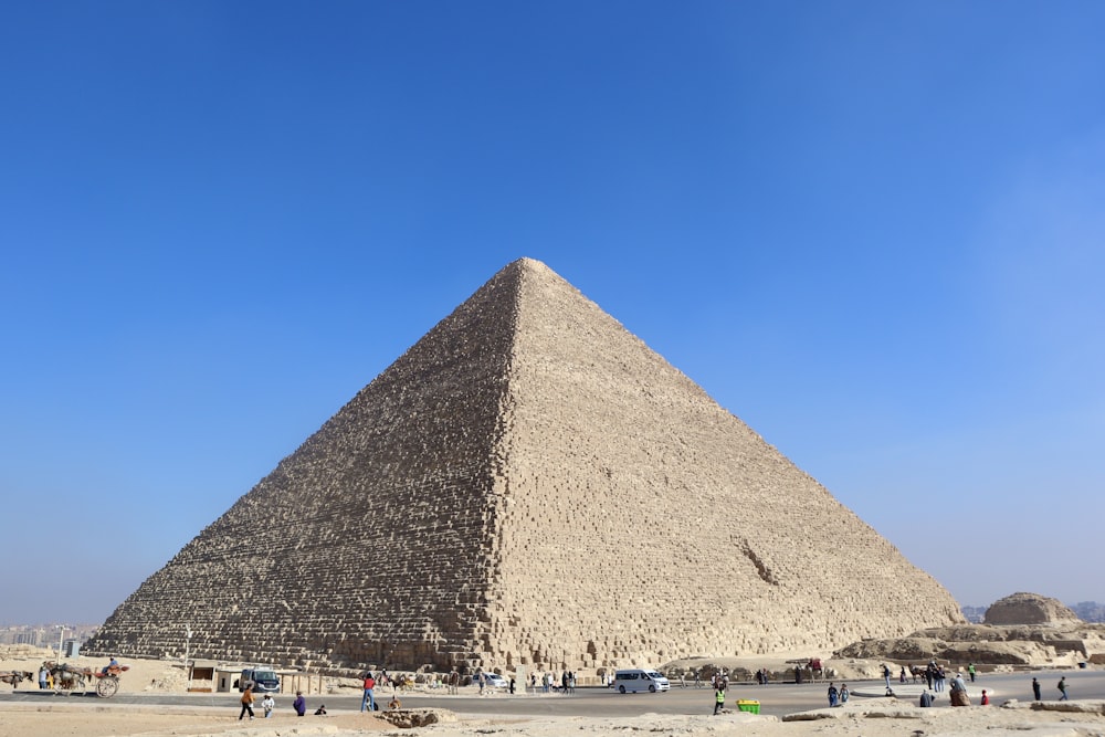 a group of people standing in front of a large pyramid