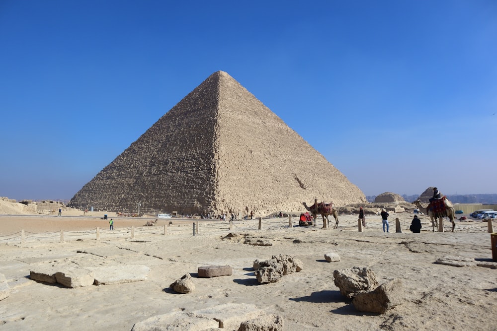 a group of people standing in front of a pyramid