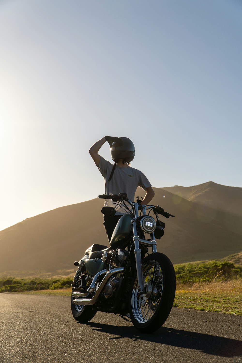 une personne assise sur une motocyclette sur une route