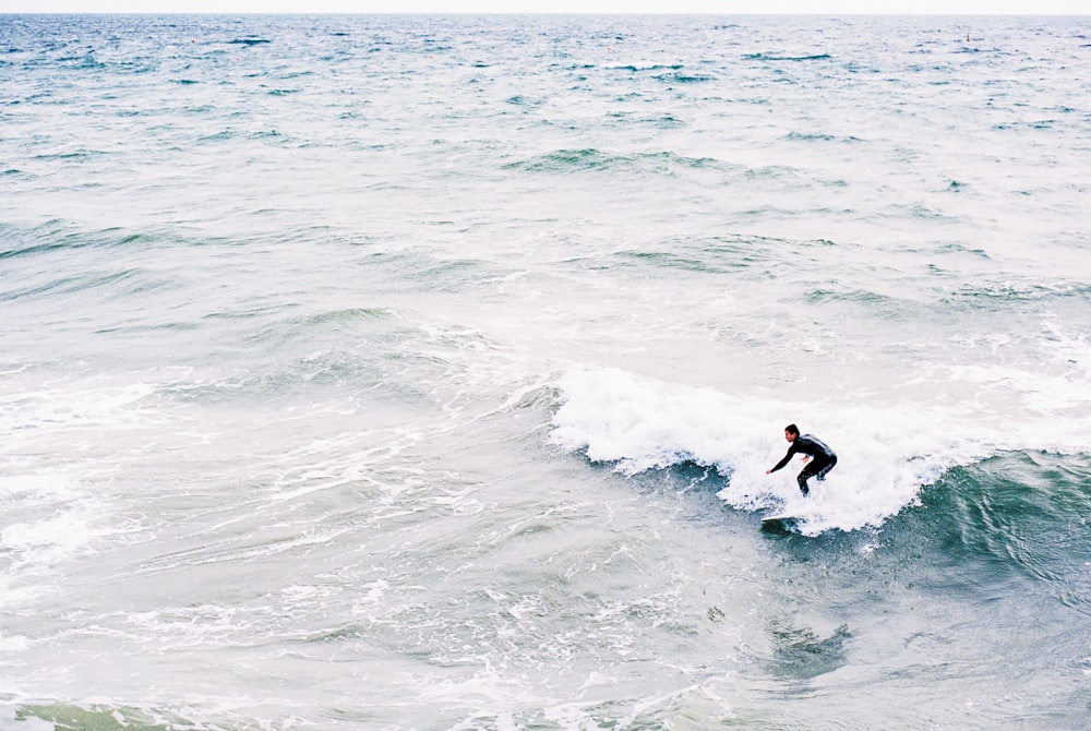 a man riding a wave on top of a surfboard