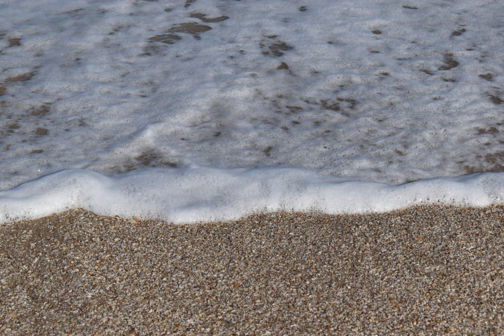 a close up of sand and water on a beach