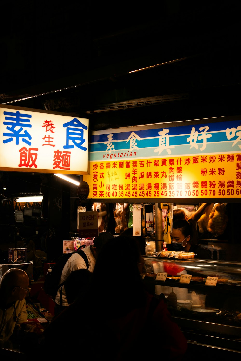 a group of people standing in front of a food stand