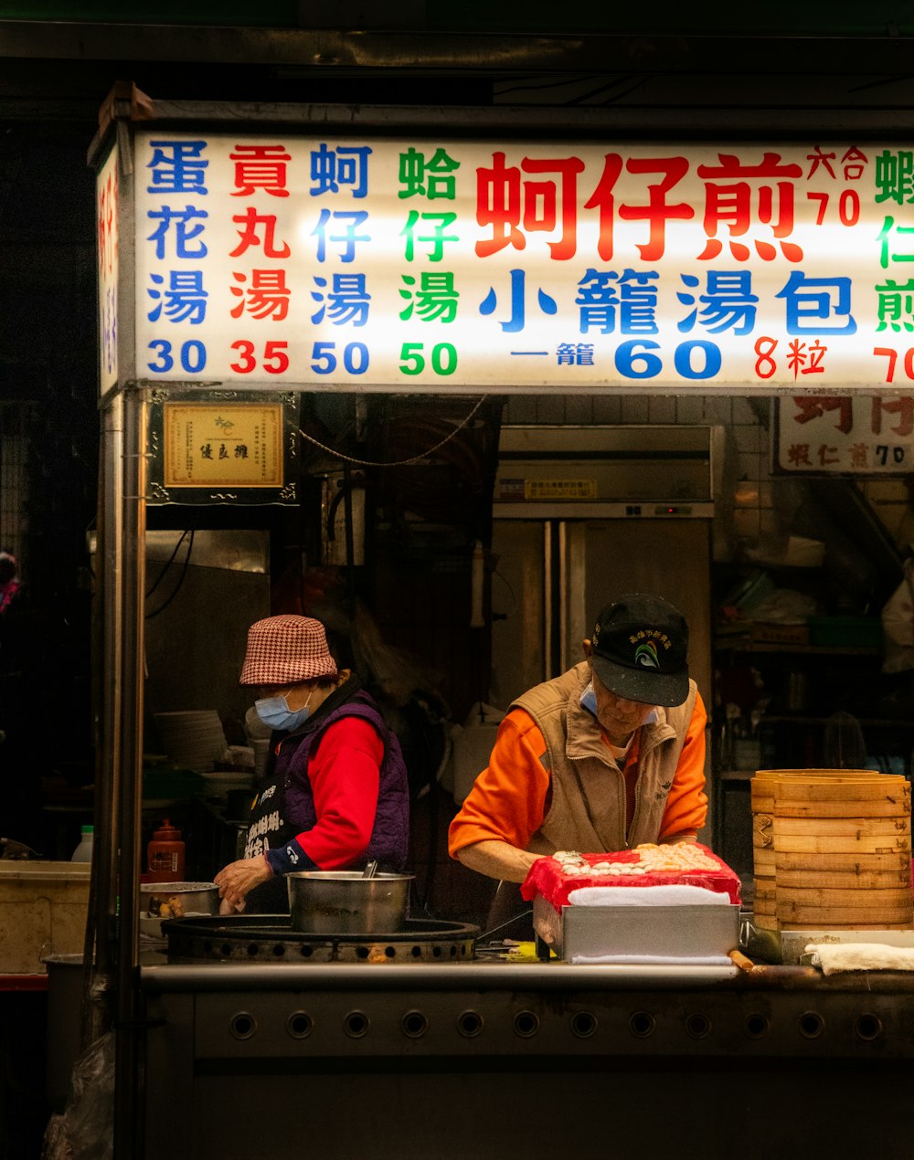 a man and a woman working at a food stand