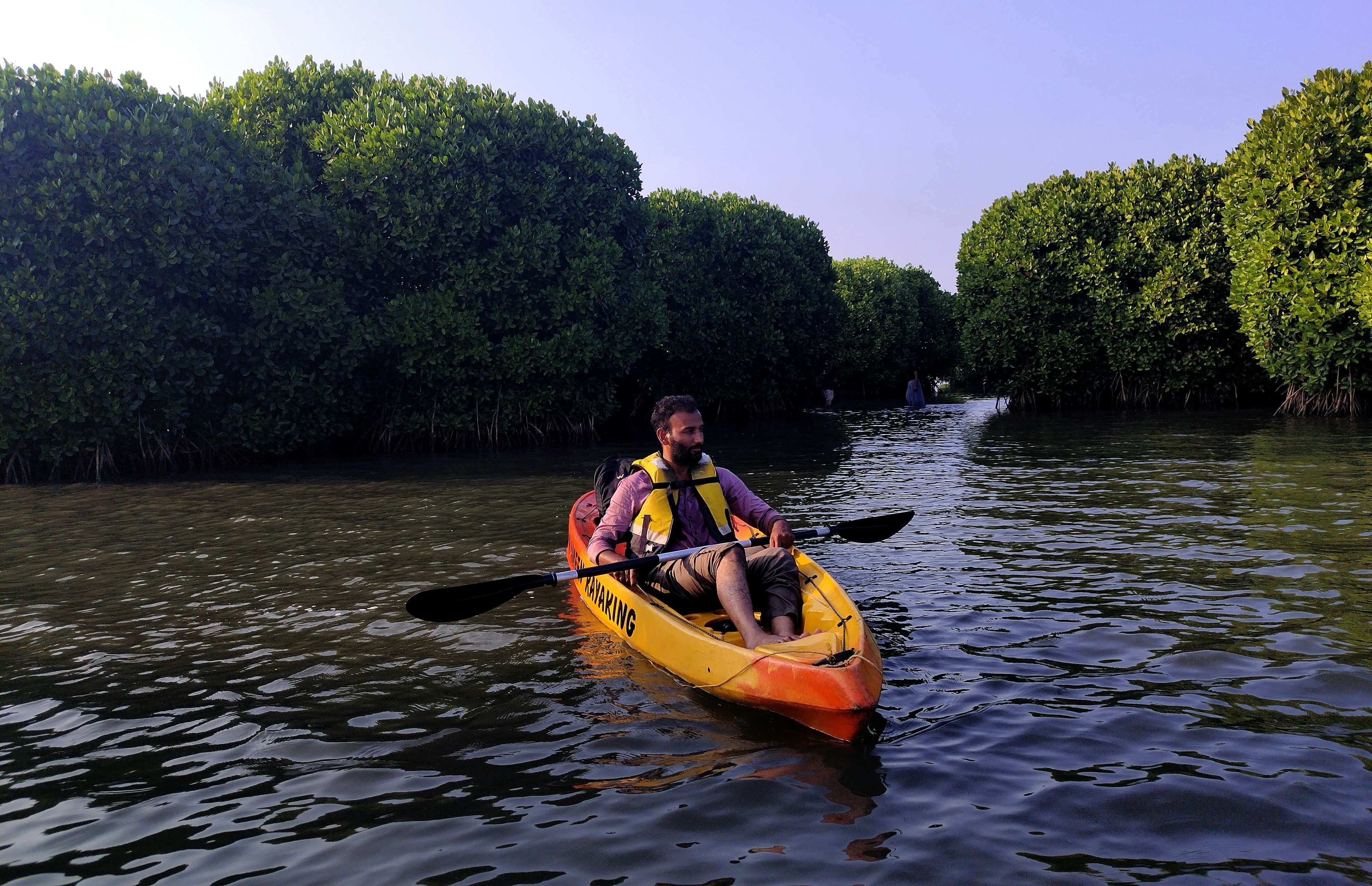 two people in a kayak paddling down a river, 