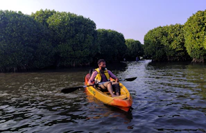 two people in a kayak paddling down a river