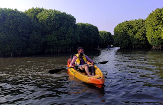 two people in a kayak paddling down a river