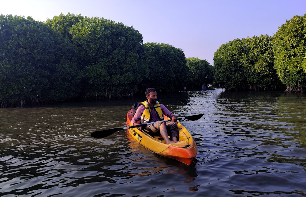 two people in a kayak paddling down a river