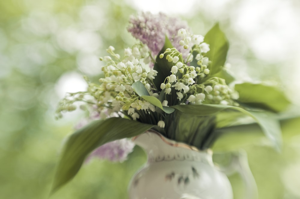 a white vase filled with flowers on top of a table