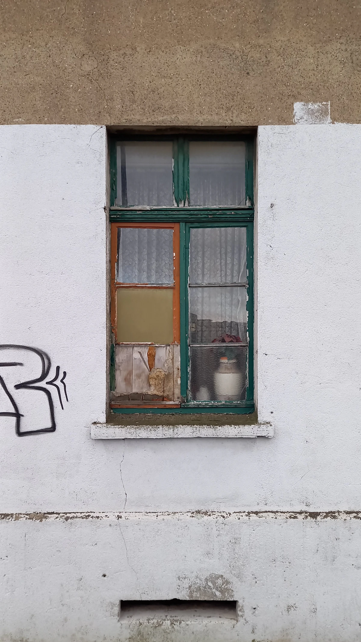 Dilapidated old mismatched window frame before replacement