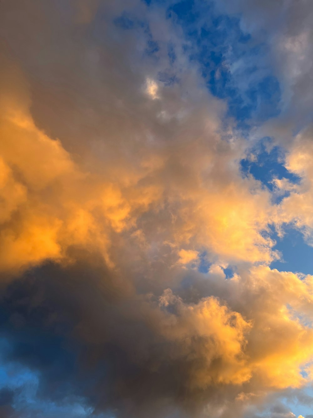 a plane flying through a cloudy blue sky