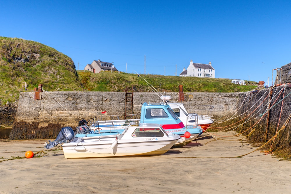 a couple of boats sitting on top of a sandy beach