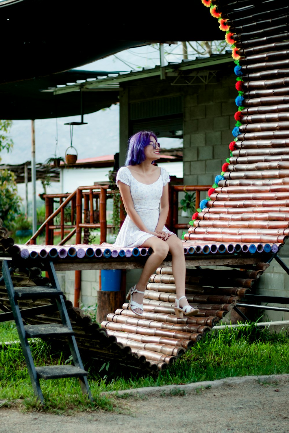 a woman with purple hair sitting on a bench