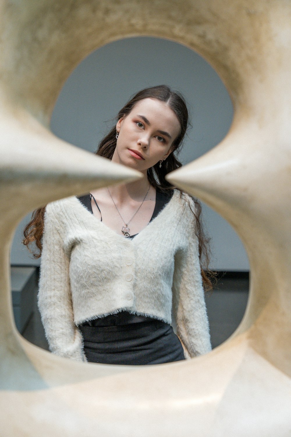 a woman standing in front of a sculpture