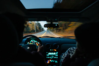 a person driving a car on a road at night
