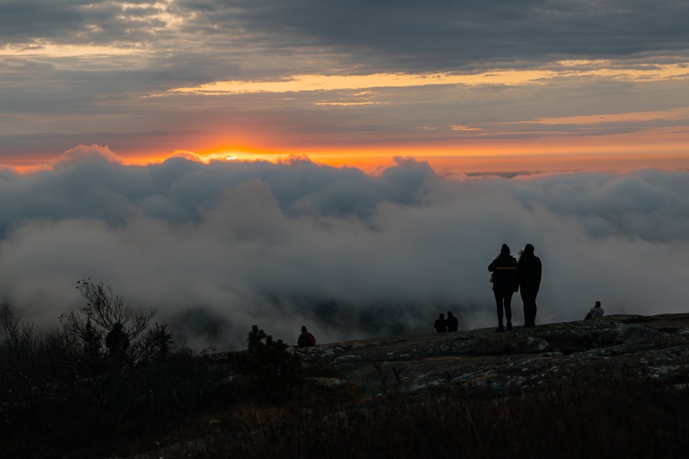 Un par de personas de pie en la cima de una montaña