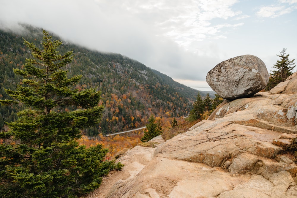 a large rock sitting on the side of a mountain