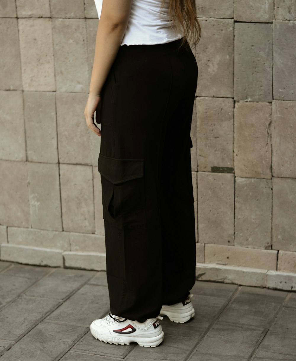 a woman standing in front of a brick wall