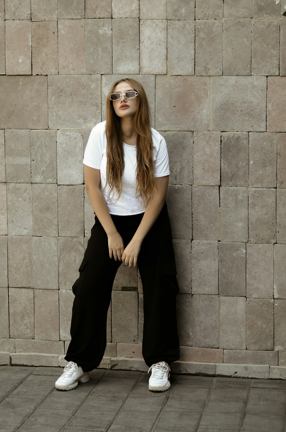 a woman sitting on a wall with her legs crossed