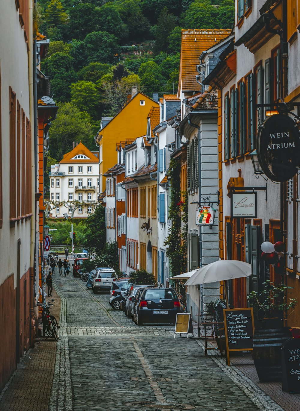 uma rua de paralelepípedos ladeada de carros estacionados