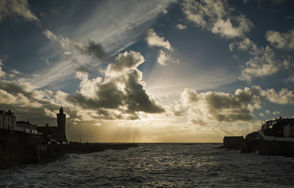 the sun is shining through the clouds over the water