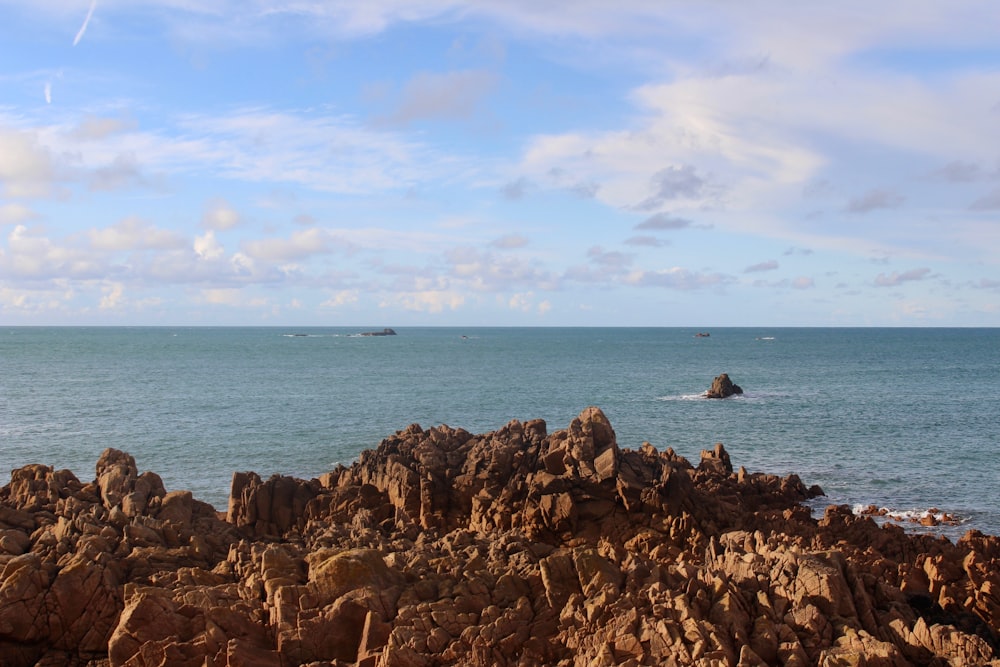 a large body of water sitting next to a rocky shore