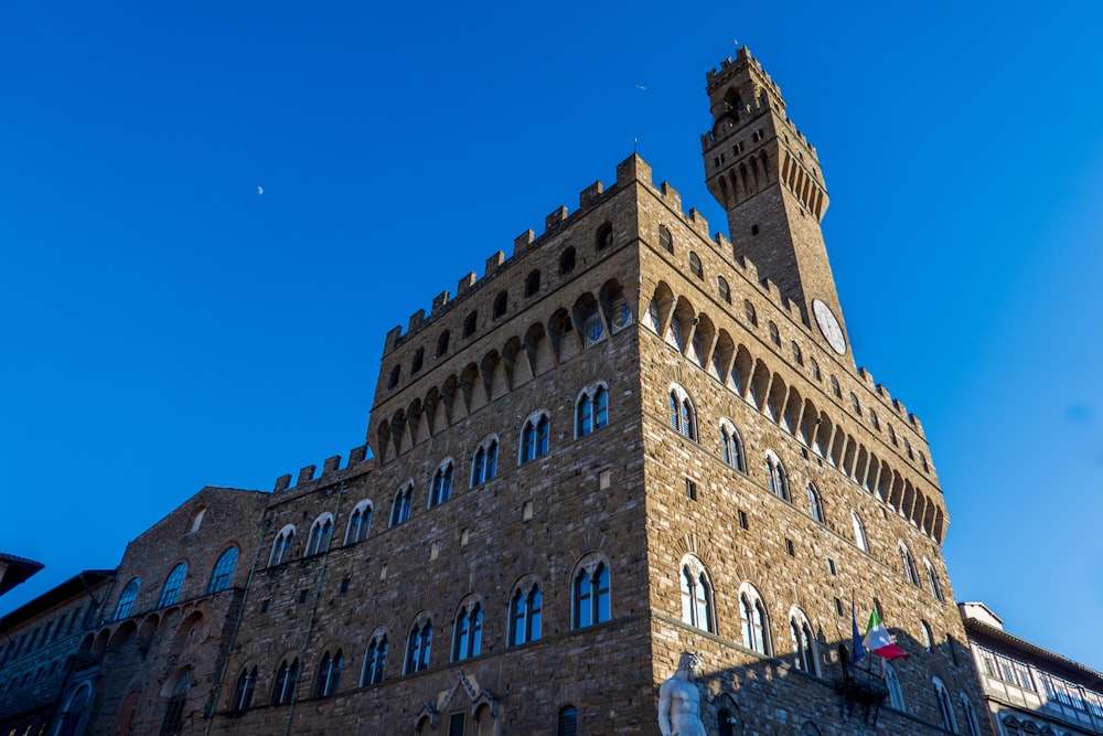 a tall brick building with a clock on it's side