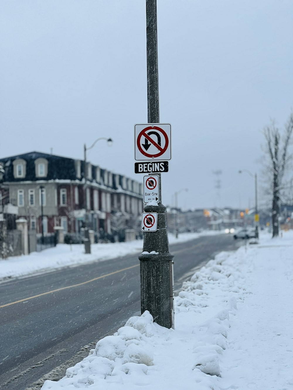 a no parking sign on the side of a snowy road