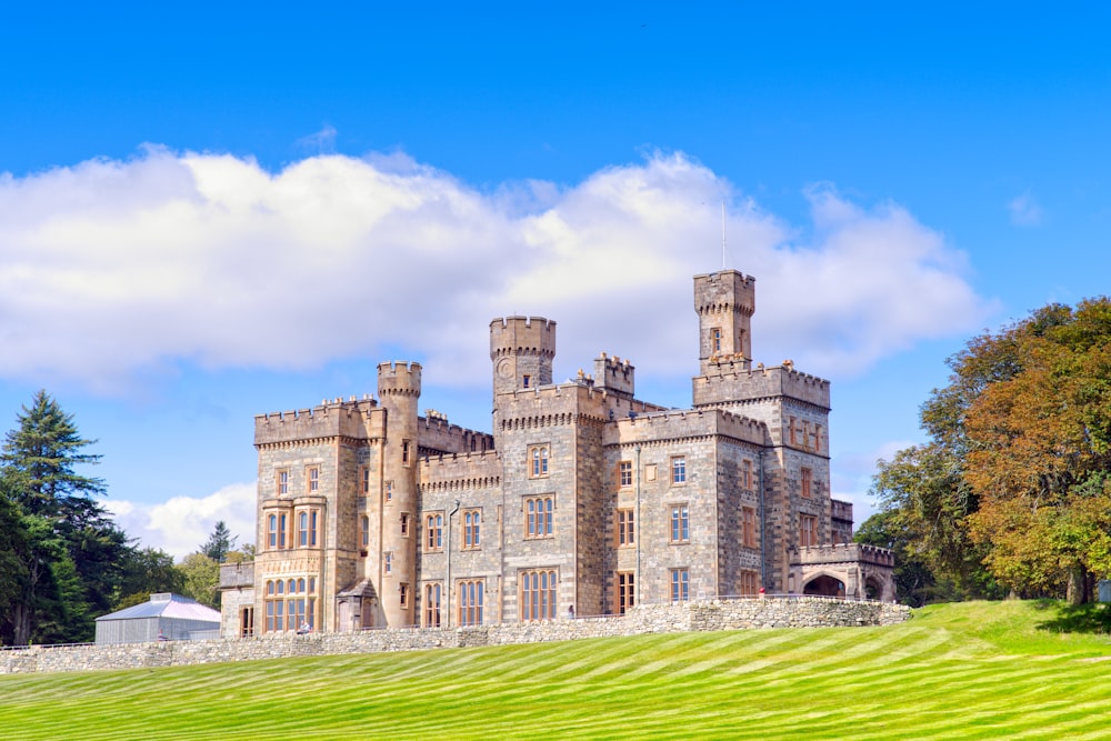 a large castle like building sitting on top of a lush green field