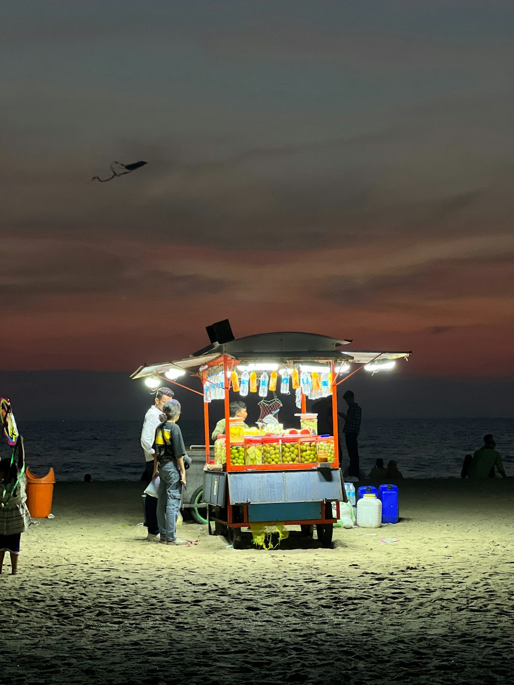 a group of people standing on top of a sandy beach