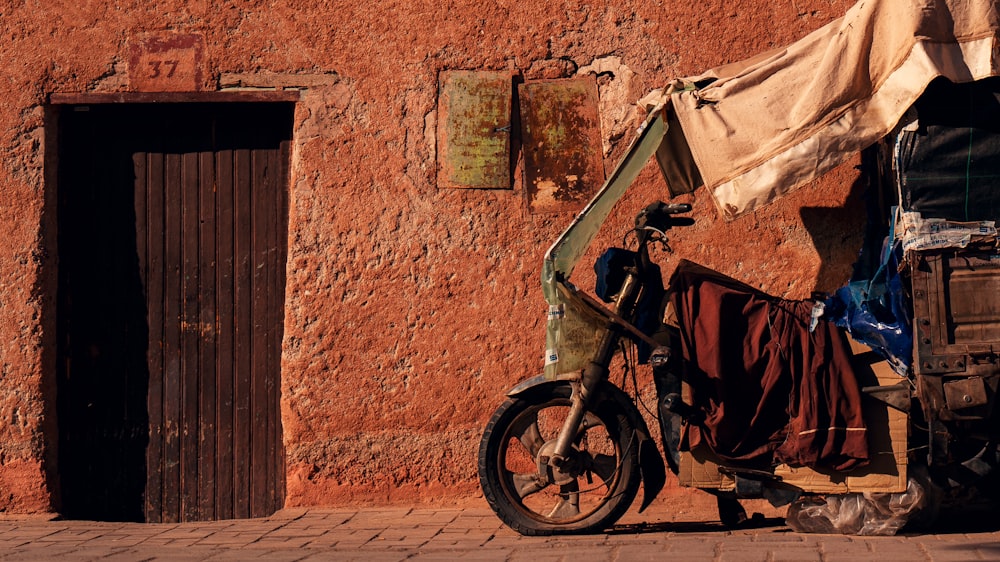 a motorcycle parked next to a building with a tarp over it