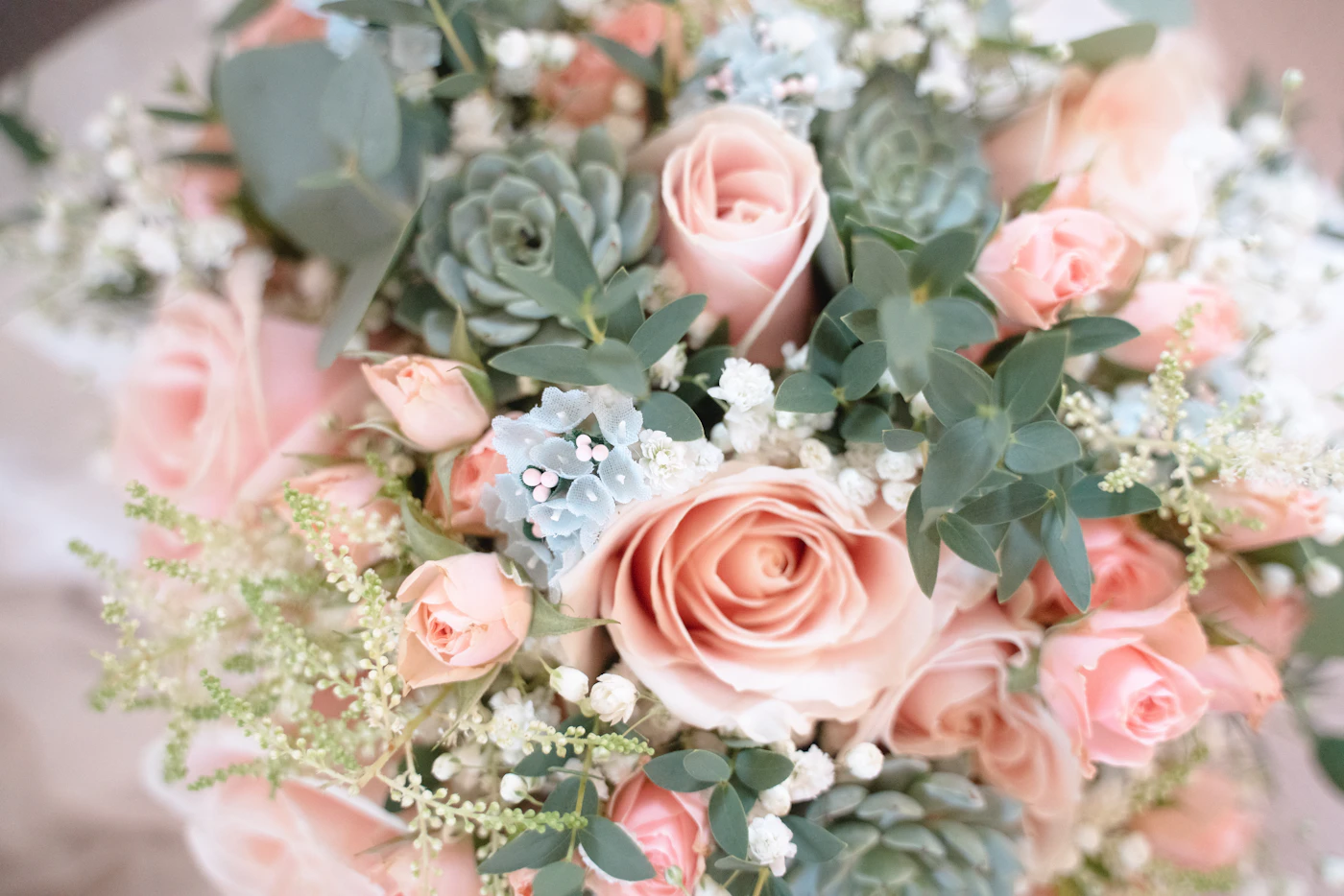 How to choose a wedding florist in your area — A bride holding a lush bouquet of peonies and garden roses.