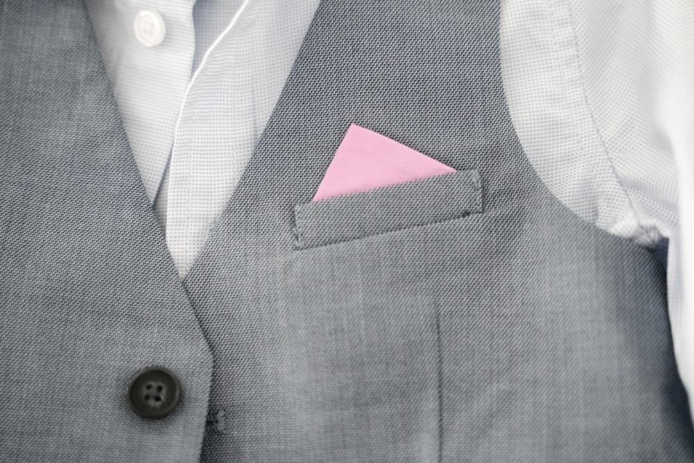 a close up of a person wearing a suit with a pink pocket