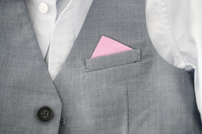 a close up of a person wearing a suit with a pink pocket