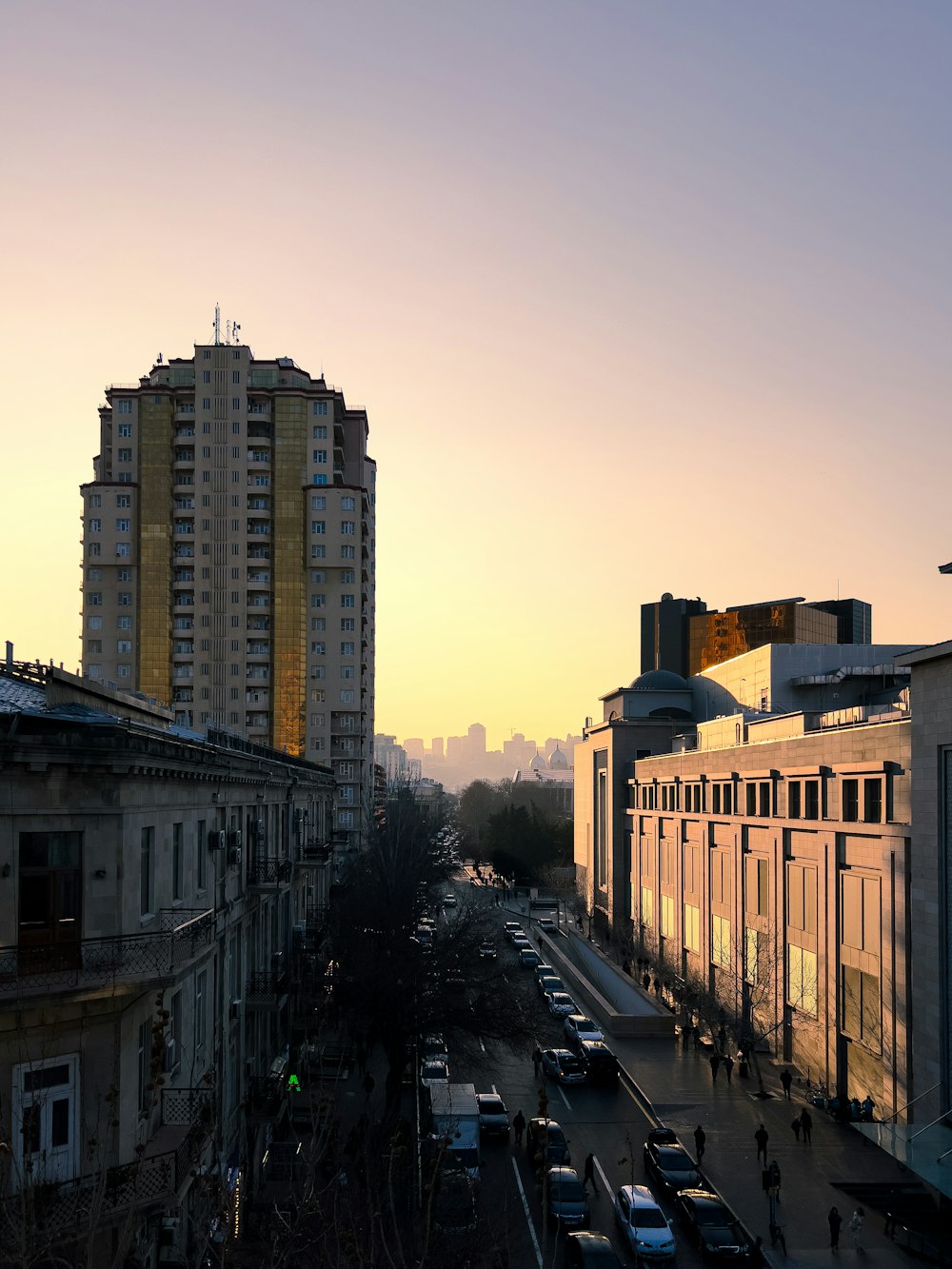 a city street filled with lots of traffic next to tall buildings