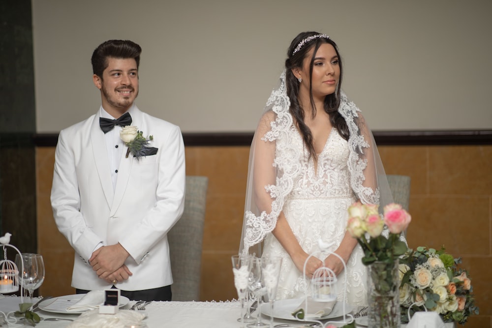 a bride and groom standing in front of a table