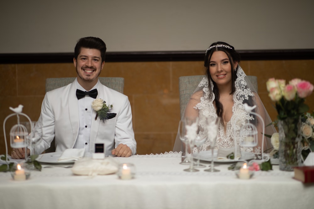 a bride and groom sitting at a table