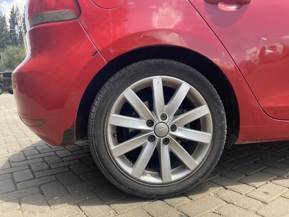 a red car parked on a brick road