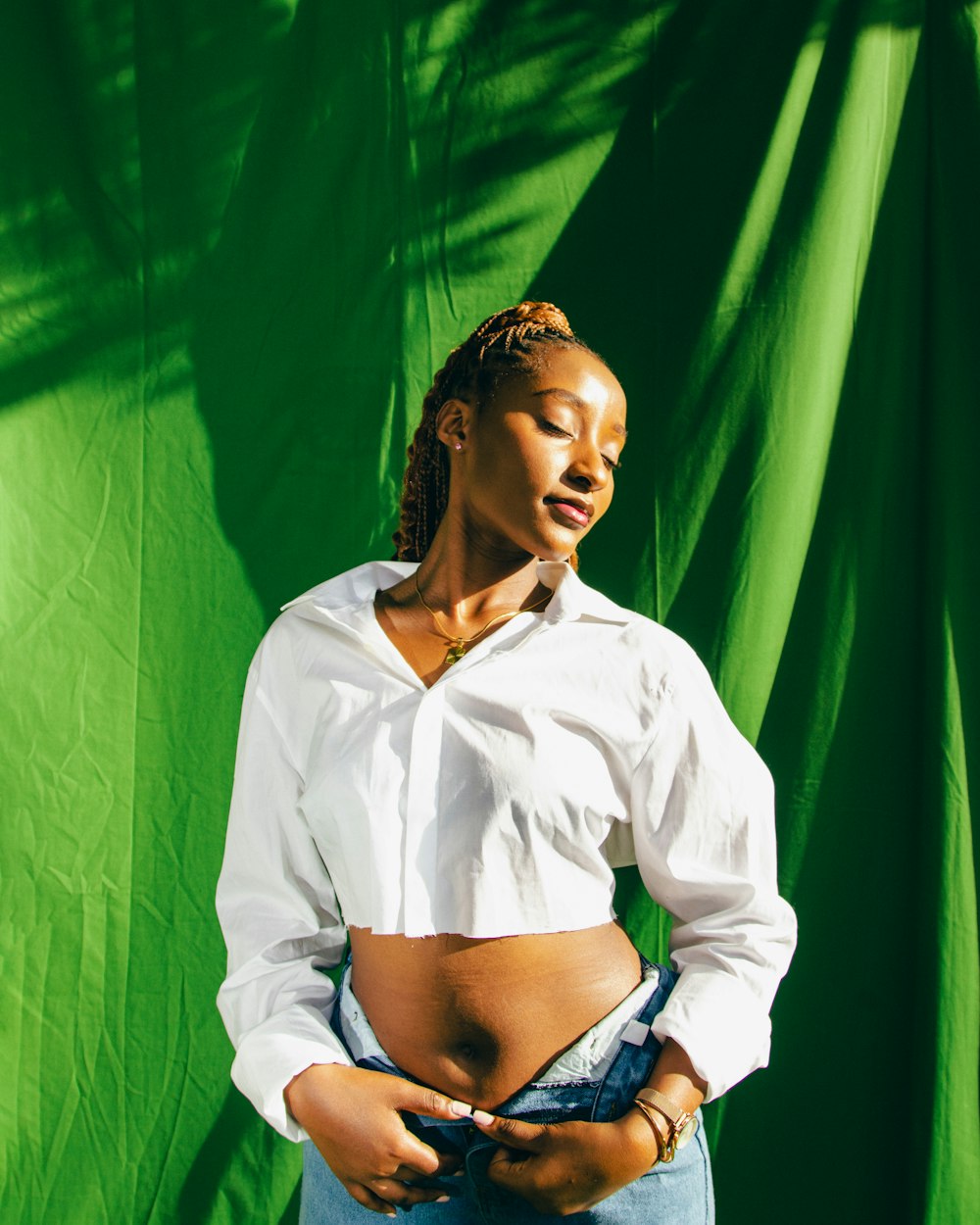 a woman standing in front of a green backdrop