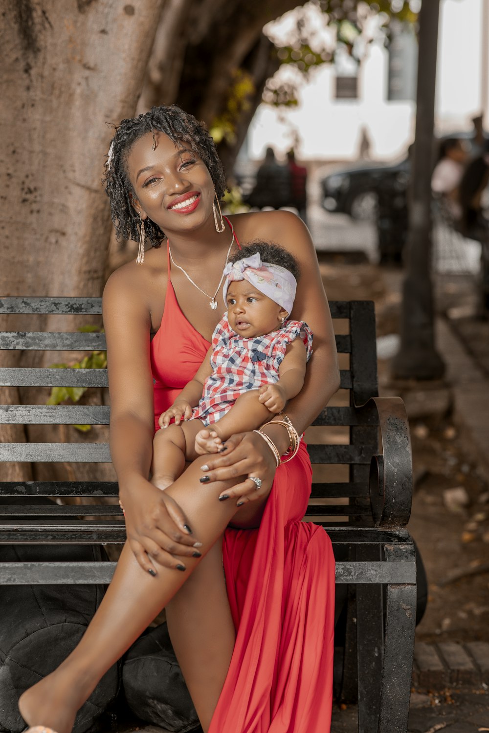a woman sitting on a bench holding a baby