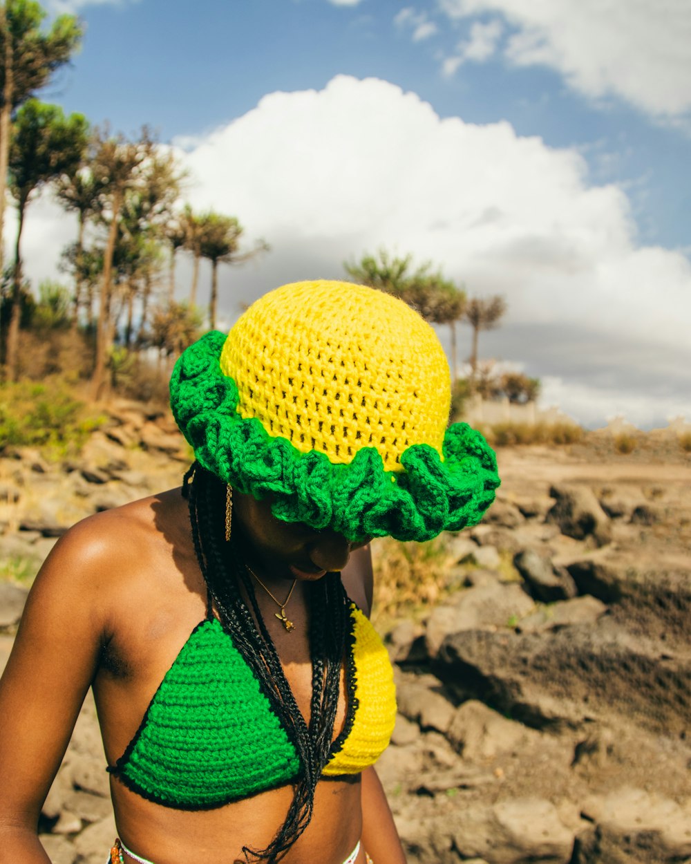 a woman wearing a yellow and green crocheted hat