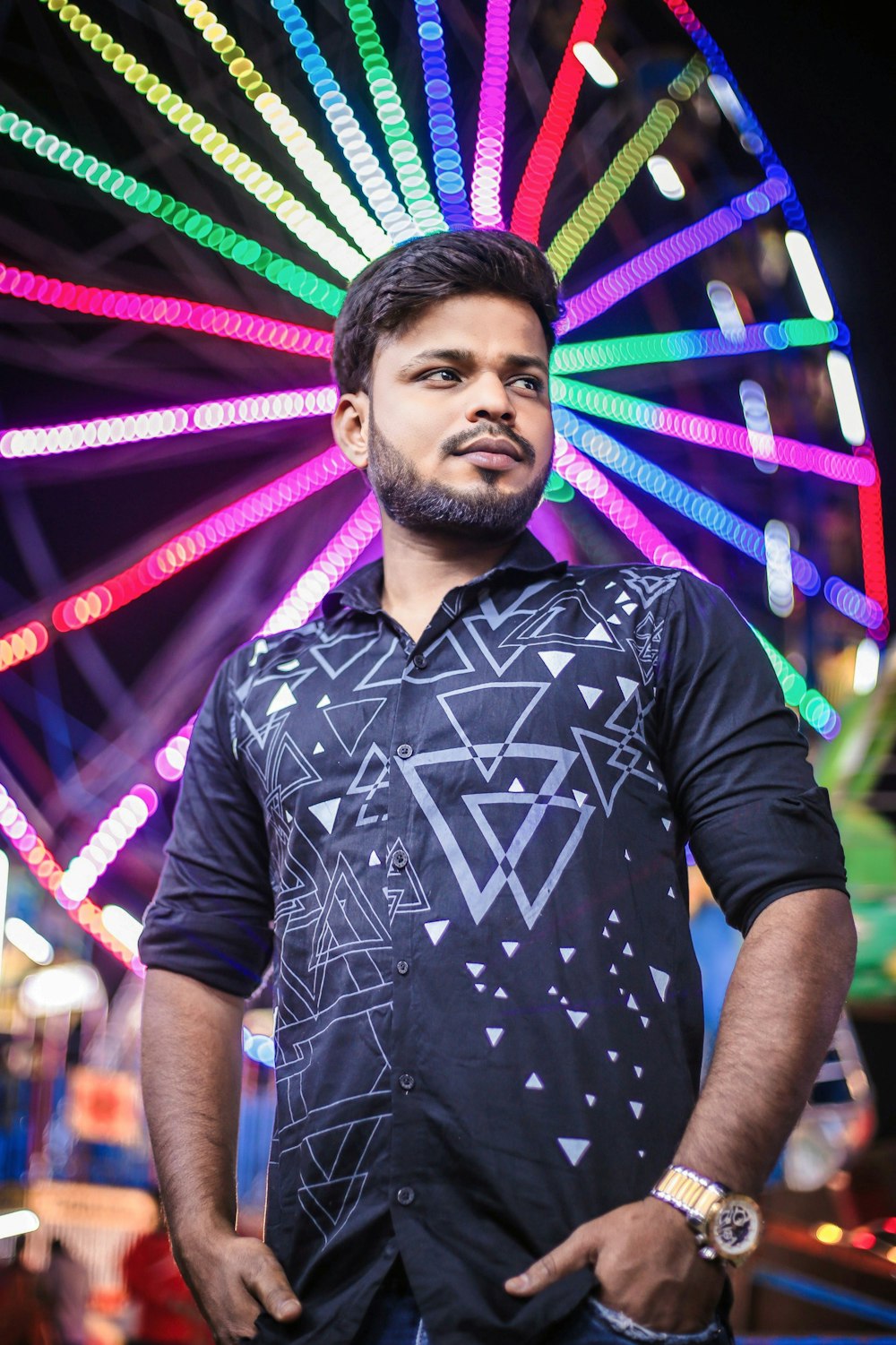 a man standing in front of a ferris wheel