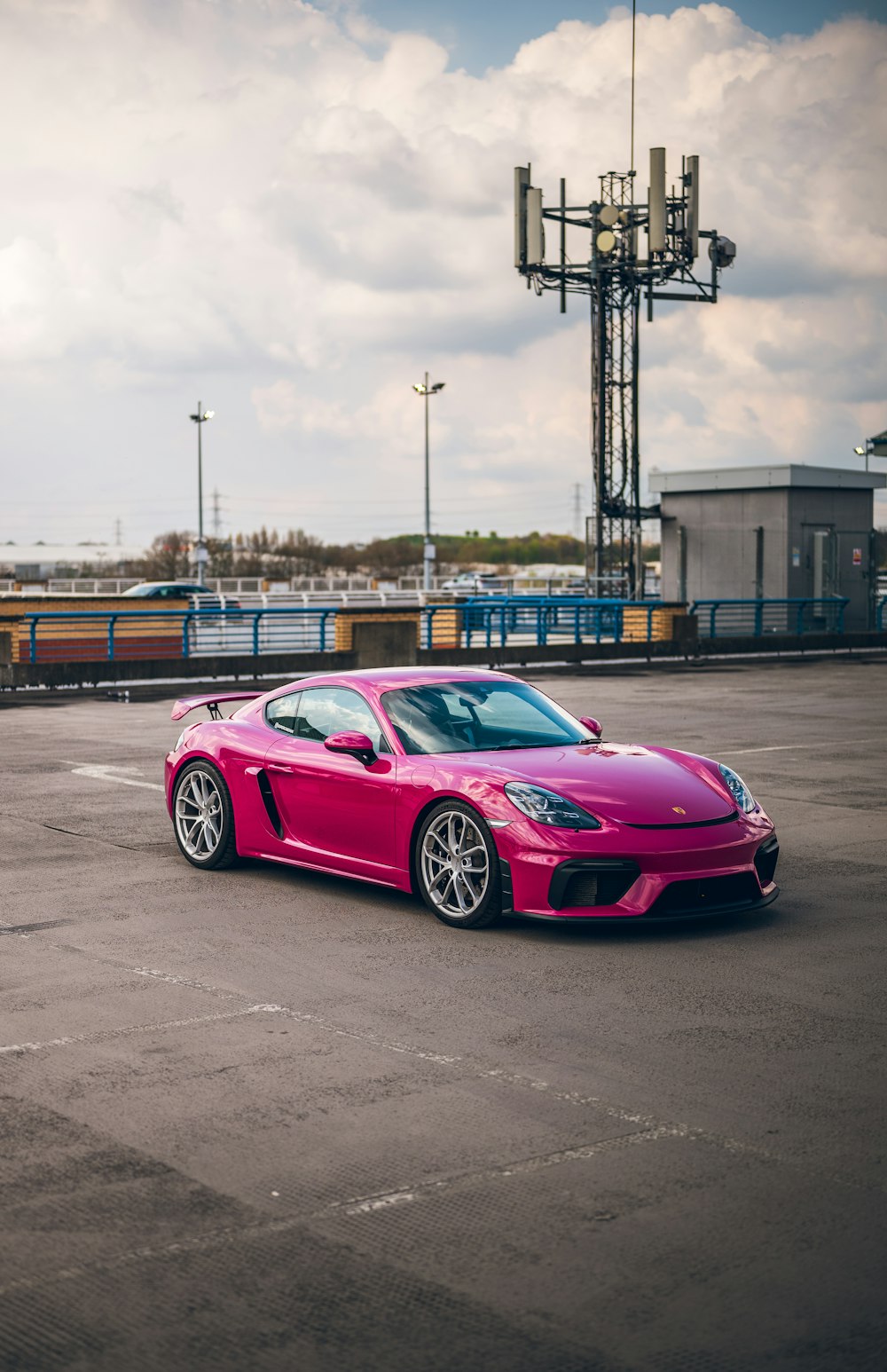 ein pinkfarbener Sportwagen, der auf einem Parkplatz geparkt ist